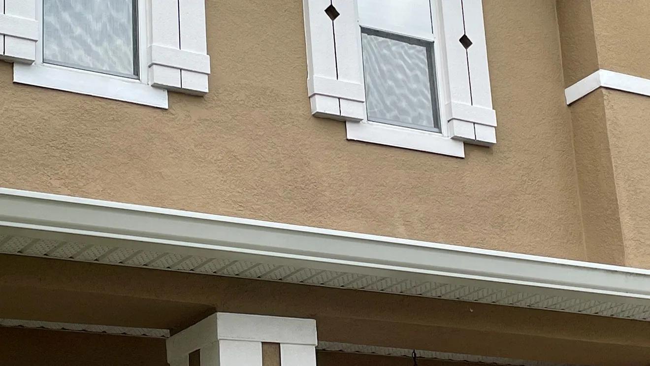 A finished stucco repair, repainted until invisible against the wall around it