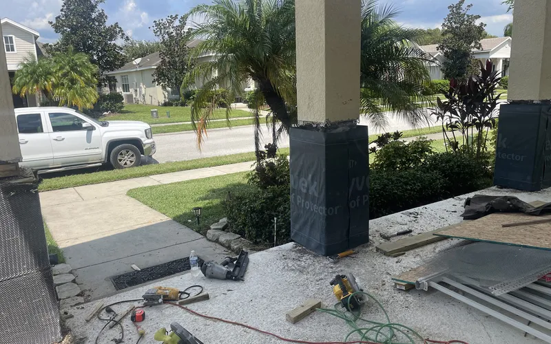 A porch column stripped to its base and wrapped in weather-resistant barrier, Central Florida example