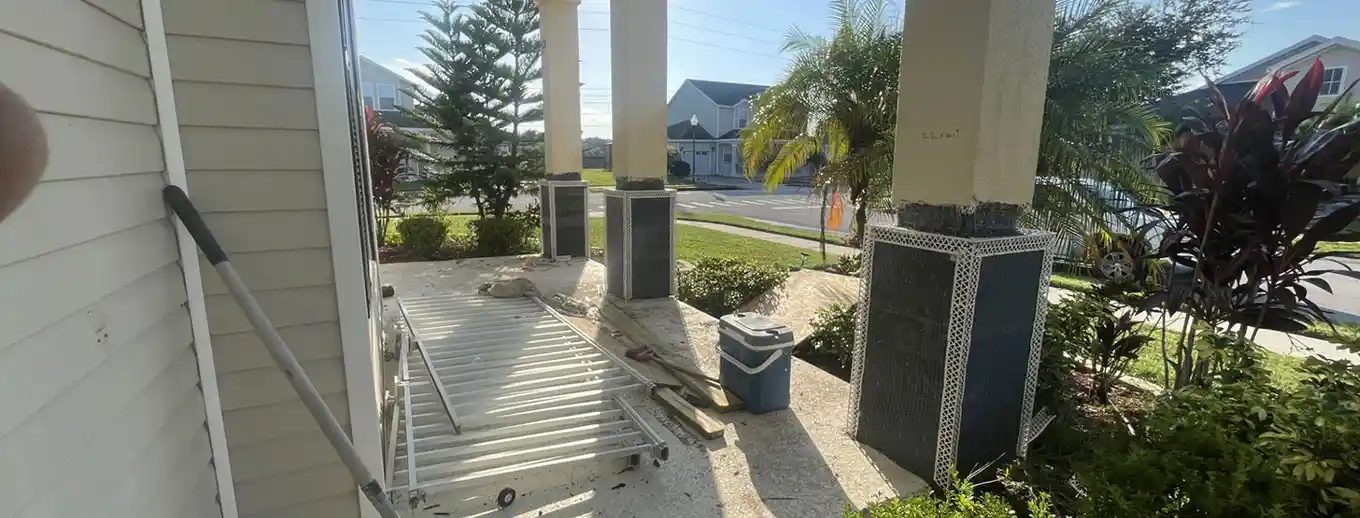 Porch columns wrapped in weather barrier and metal lath mid-repair