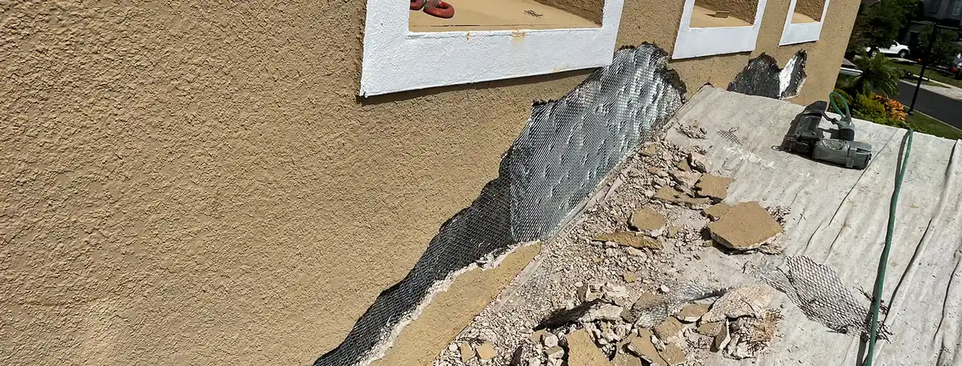 Stucco cut back to bare metal lath below a window, Central Florida example